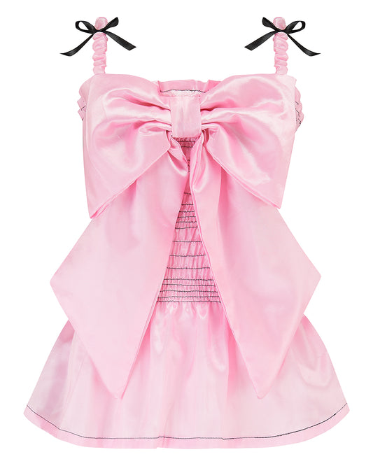 A baby pink taffeta top with a large bow detail on the front, black topstitch elasticated shirring bodice, and black ribbon bow shoulder straps. Delta Of Phoenix Genie Bow Top