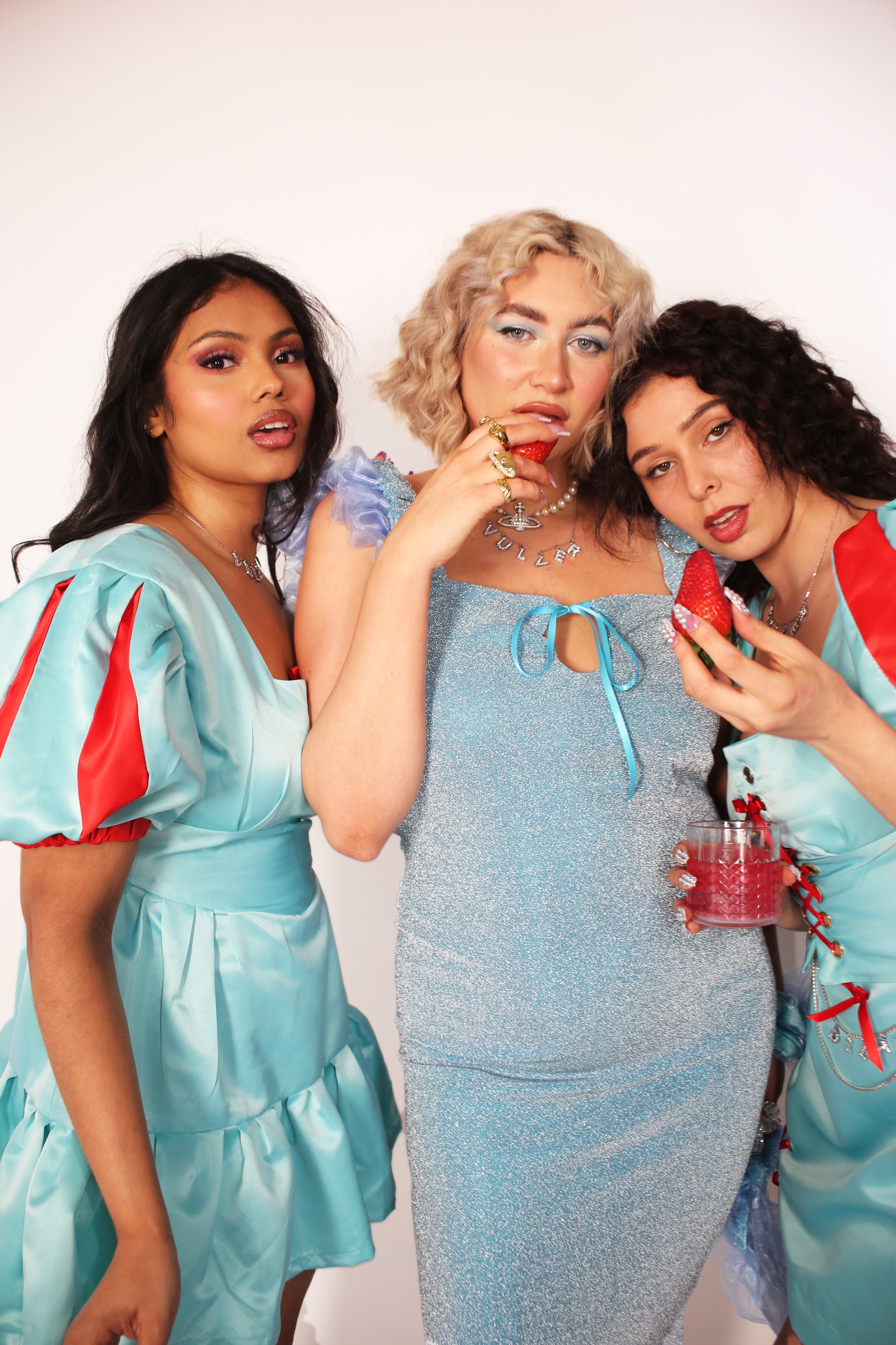 A blue glitter cocktail dress with ruffle detailing, elasticated ruched straps, and a ribbon bow keyhole detail at the front. Delta Of Phoenix Juni Midi Dress