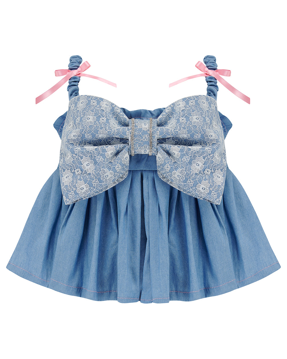 A denim crop top with a large white lace bow and diamante detail on the chest, pink topstitch elasticated shirring across the top bodice, and full babydoll gathered panel. It features elasticated shoulder straps with pink ribbon bow detail. Delta Of Phoenix Gigi Bow Top
