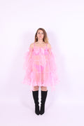 A bubblegum pink organza mini dress with a large bow detail at the sleeve, skirt, and front, featuring a bardot neckline and long puff sleeves. Cosette Dress by Delta Of Phoenix