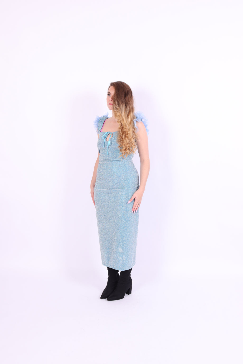 A blue glitter cocktail dress with ruffle detailing, elasticated ruched straps, and a ribbon bow keyhole detail at the front. Delta Of Phoenix Juni Midi Dress