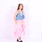 A denim crop top with a large white lace bow and diamante detail on the chest, pink topstitch elasticated shirring across the top bodice, and full babydoll gathered panel. It features elasticated shoulder straps with pink ribbon bow detail. Delta Of Phoenix Gigi Bow Top